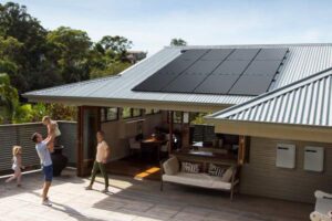 Silhouette solar panels on roof with family in foreground